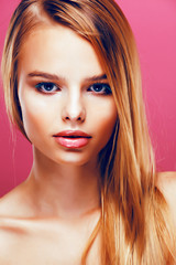 Fototapeta premium young pretty blonde real woman with hairstyle close up and makeup on pink background smiling, stylish fashion look like baby doll