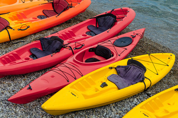 kayaks of different colors on the beach.
