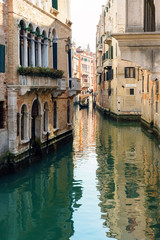 Obraz na płótnie Canvas Narrow canal with green water with reflections