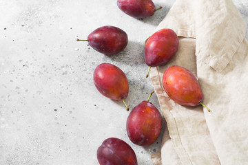Red plums on the grey table
