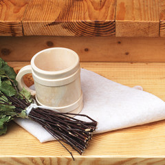 Pampering and relaxing in the sauna. Accessories for a steam room, wooden furniture, a bath broom and mug.