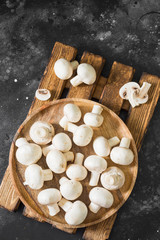 Mushrooms in a wooden bowl. Dark background