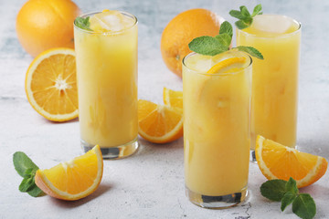 Obraz na płótnie Canvas Glasses full of orange juice with ice 