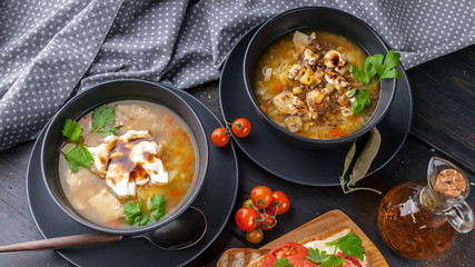 Fototapeta premium Food banner: close-up two servings of homemade pea soup with chicken, vegetables, parsley, spices and toast.