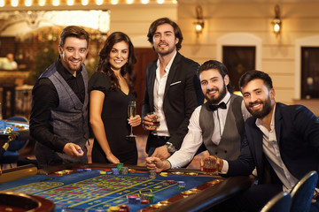 A group of friends at the casino roulette table.