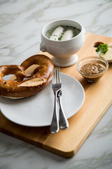 Münchener Weißwurst in Terrine mit bayrischer süßen Senf, Brezel und Butter auf Holz Brett