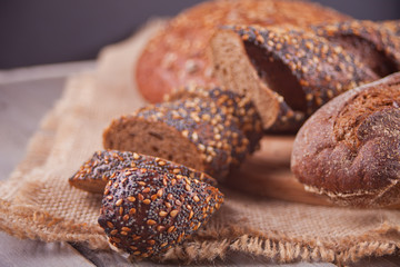 freshly baked rye bread with cereal and seeds on wooden kitchen table