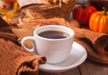 Cup of coffee, autumn leaves, pumpkin, cookies and sweater on the wooden table. Autumn harvest. Autumn concept.