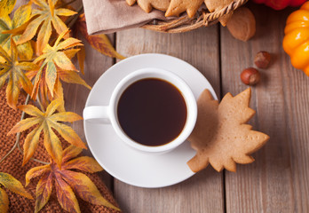 Cup of coffee, autumn leaves, pumpkin, cookies on the wooden table. Autumn harvest. Autumn concept. Top view.