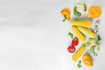 Autumn dinner cooking ingredients, various raw organic vegetables and greens on white kitchen table, copy space