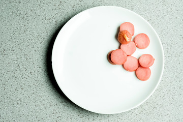 sausage cut into pieces on white plate isolated cement background