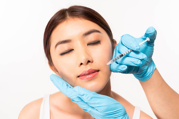 Young asia woman getting lip injection on white background