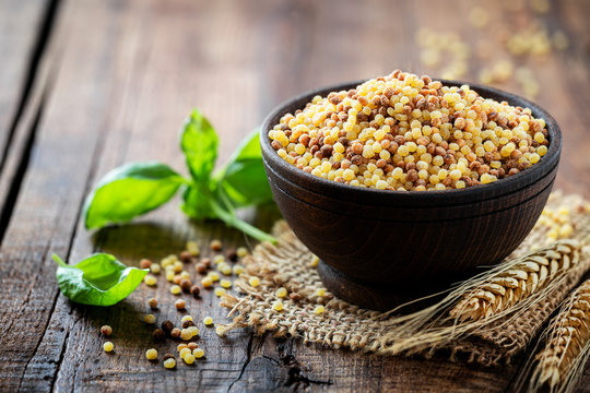 Fregola sarda with fresh basil - traditional durum wheat ball shaped toasted pasta typical of Sardinia region of Italy