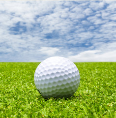Golf ball on tee with blue sky