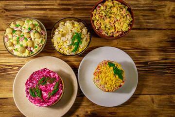 Set of festive mayonnaise salads on wooden table. Top view