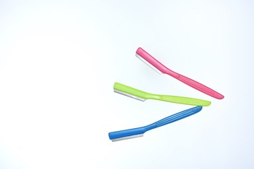 collection of colorful plastic handle razor used on white background