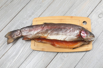Red trout smoked fish, on a wooden chopping Board .