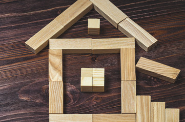 Obraz na płótnie Canvas house of wooden blocks, on a wooden background, concept.