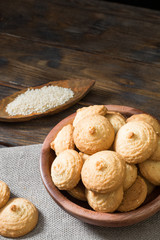Sesame biscuit in a wooden bowl on a wooden posthole. Rustic style
