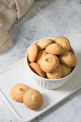 Sesame cookies in a white bowl on a light gray background