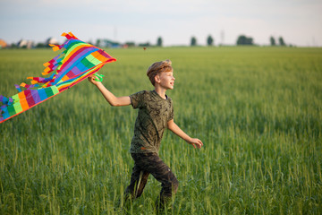 A child plays with a kite at sunset in the field.