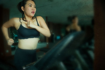 Obraz na płótnie Canvas young attractive and fit Asian Korean woman doing running workout at hotel gym or fitness club jogging in treadmill training hard in healthy lifestyle and body care