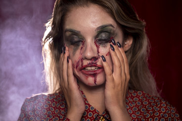 Woman with make-up as blood holding her head