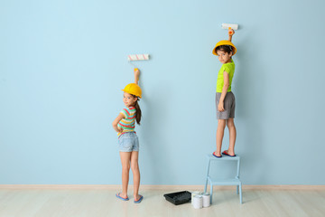 Cute little children painting wall in room