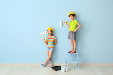 Cute little children painting wall in room