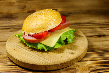 Fresh delicious homemade cheeseburger on wooden table