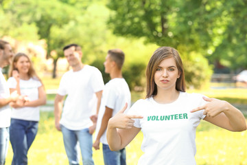 Female volunteer pointing at her t-shirt outdoors