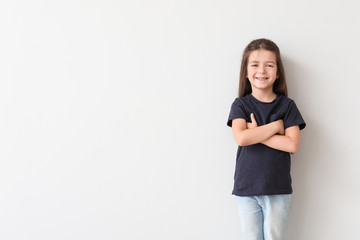 Little girl in stylish t-shirt on light background