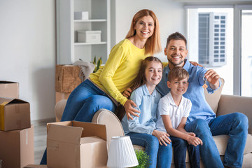 Happy family with belongings and keys in their new house