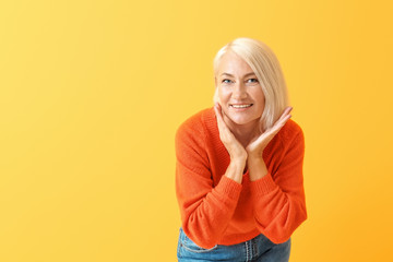 Stylish mature woman on color background