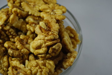 a bowl full of raw walnut in white background