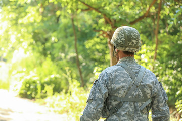 Fototapeta na wymiar Male soldier in camouflage outdoors, back view