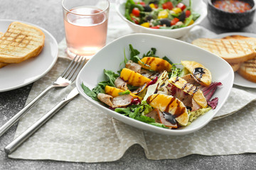 Plate with tasty salad on table