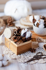 Family time to wrap christmas presents! Ideas for hand made gifts decor in rustic style, natural ingredients, cozy mood. Wooden background, scissors, lace, cones, cinnamon and cotton. Zero waste 