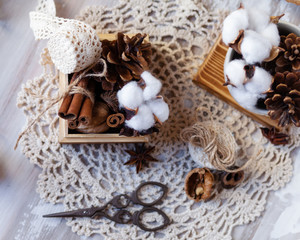 Time to wrap christmas presents! Ideas for hand made gifts decor rustic style, natural ingredients, cozy mood. Wooden background, scissors, rope, lace, cones, cinnamon and cotton. Flat lay top view