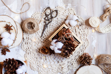 Time to wrap christmas presents! Ideas for hand made gifts decor rustic style, natural ingredients, cozy mood. Wooden background, scissors, rope, lace, cones, cinnamon and cotton. Flat lay top view