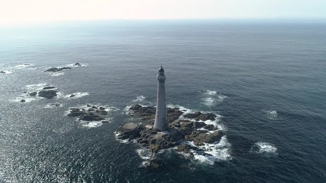 Aerial slow motion high above Skerryvore lighthouse in shimmering sunshine