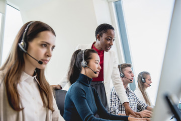 Female supervisor working with team in call center - Powered by Adobe