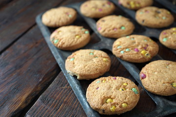 Homemade cookies on the grill of the oven. Dark wooden background