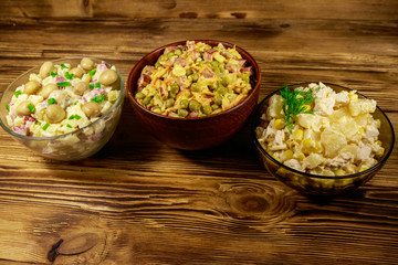 Set of festive mayonnaise salads on wooden table