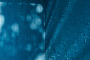 Bright blue wall with shadow from trees
