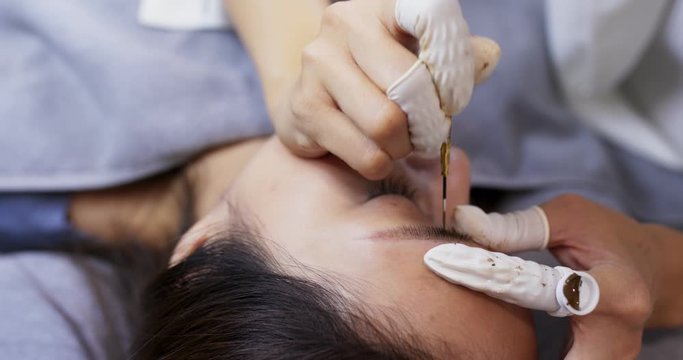 Close up of cosmetologist making microblading procedure