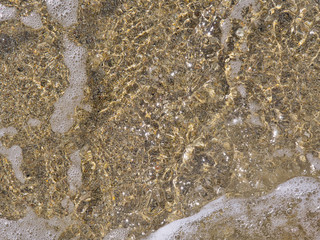 Close up on sandy beach sea water