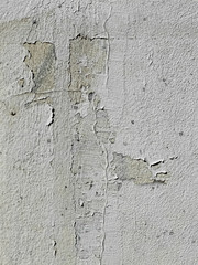 mur de béton blanc fendu présentant de nombreuses asperités