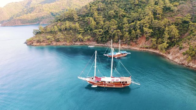 Aerial top view of luxury sailing gulets and yachts on the turquoise mediterranean sea in Turkey near Greek border.