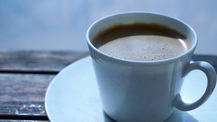 close up on ceramic cup of coffee on wooden table